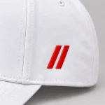 Close-up of red embroidered double slashes on the white SPEAK//UP cap